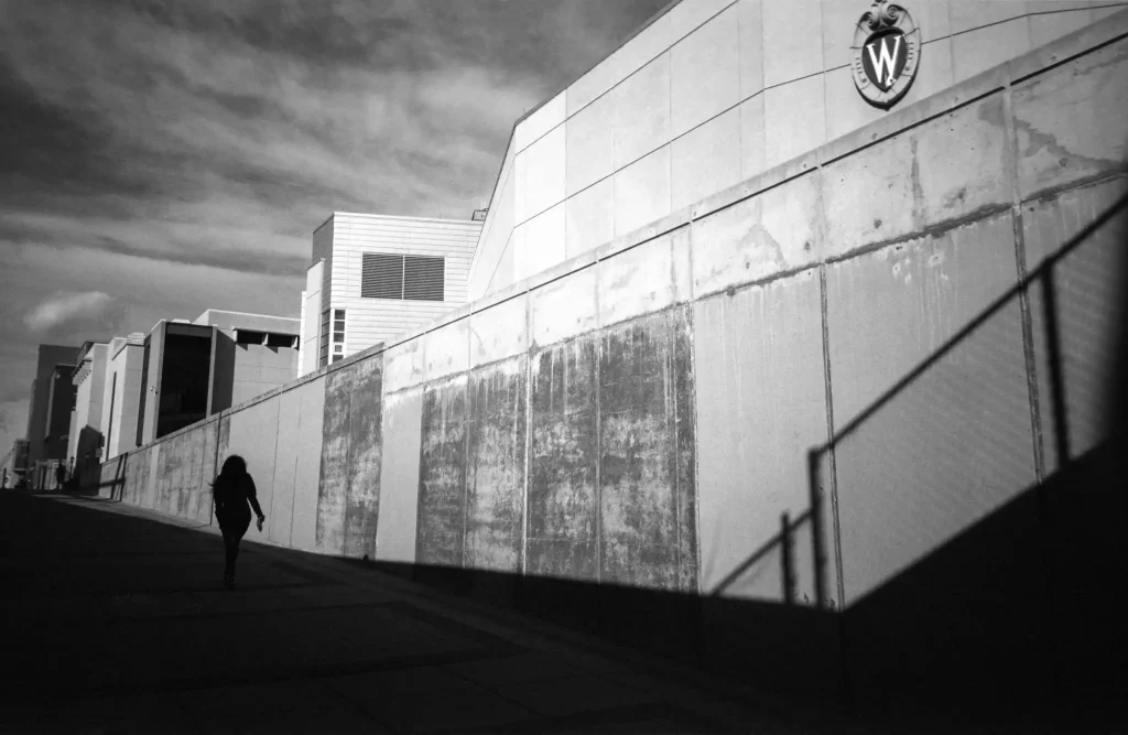 Photo of woman walking behind UW-Madison Kohl Center.