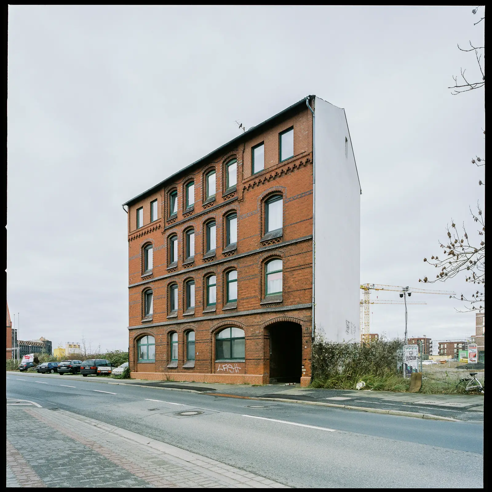 6x6 photograph of a run-down apartment house made out of red bricks
