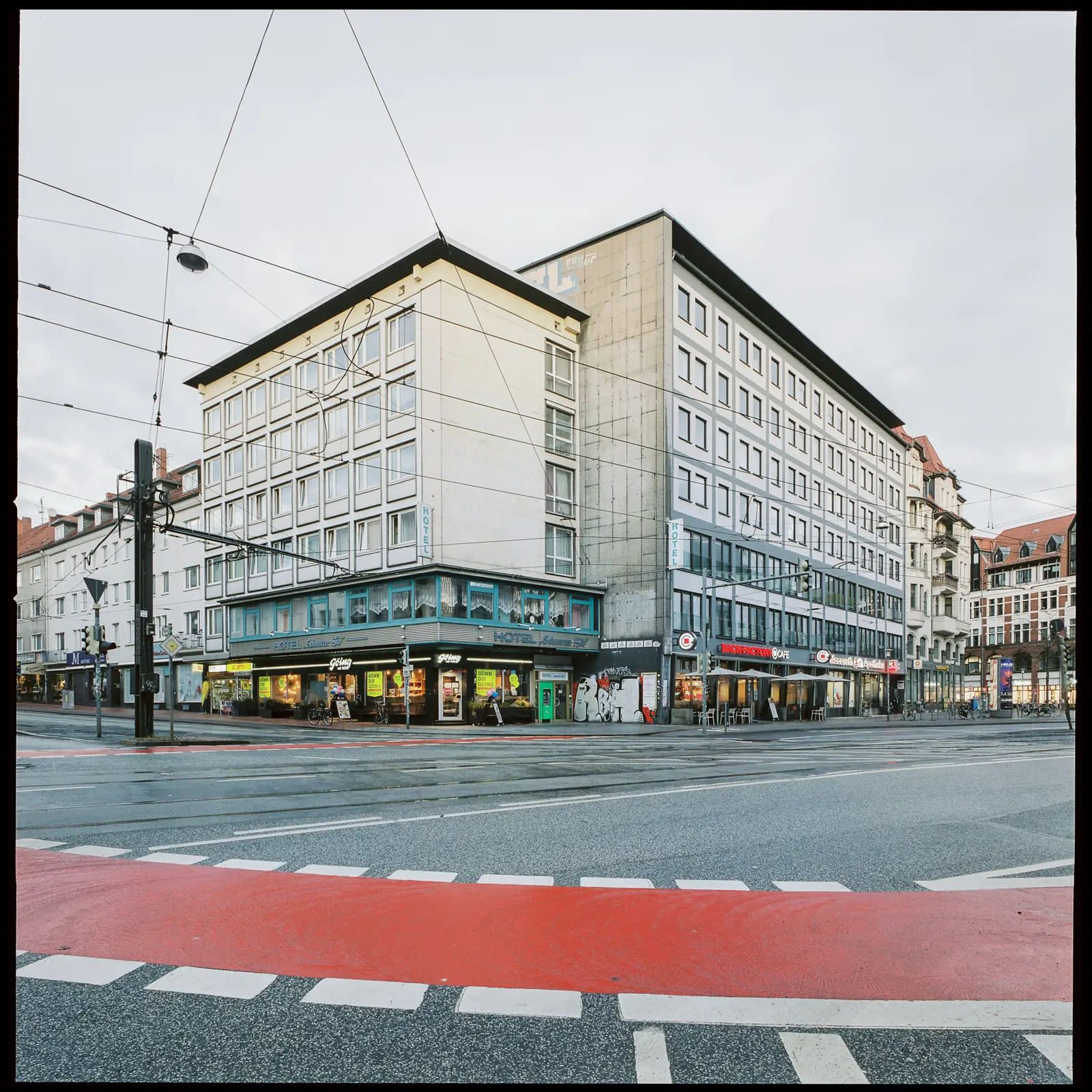 Schwarzer Bär town square with a red bike lane in the foreground and a gray building complex in the background