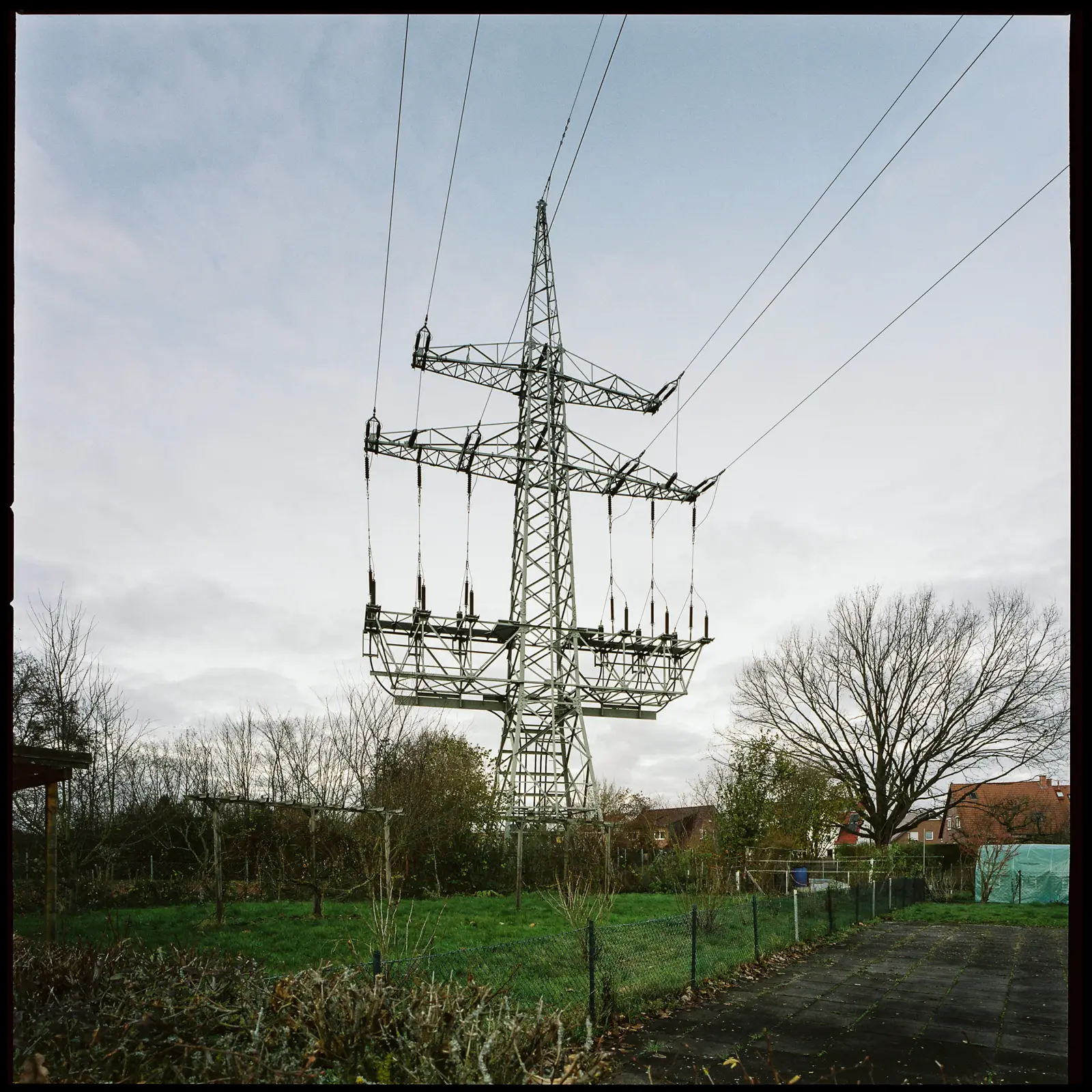 6x6 photograph of a large powerpole in front of a slightly cloudy evening sky