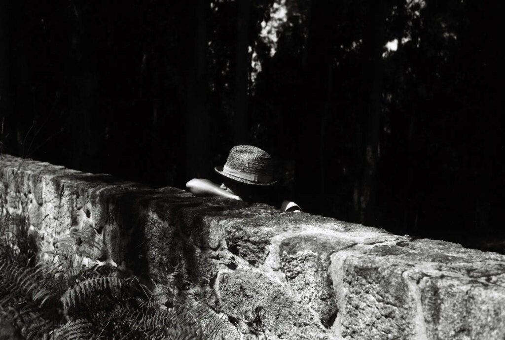 man resting on stone wall
