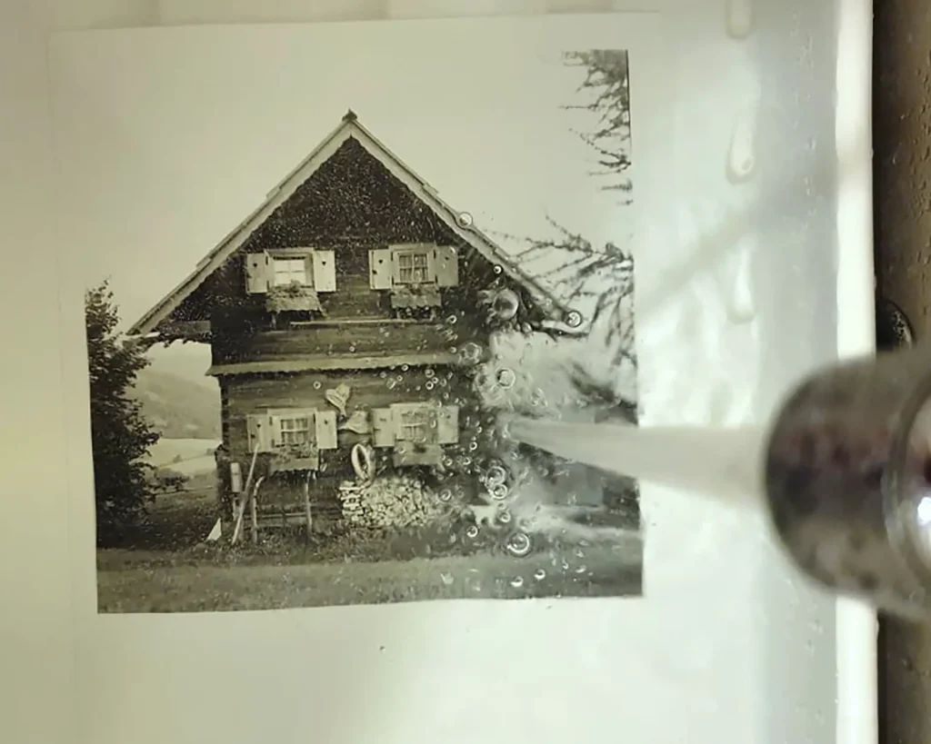 running water onto picture of alpine house