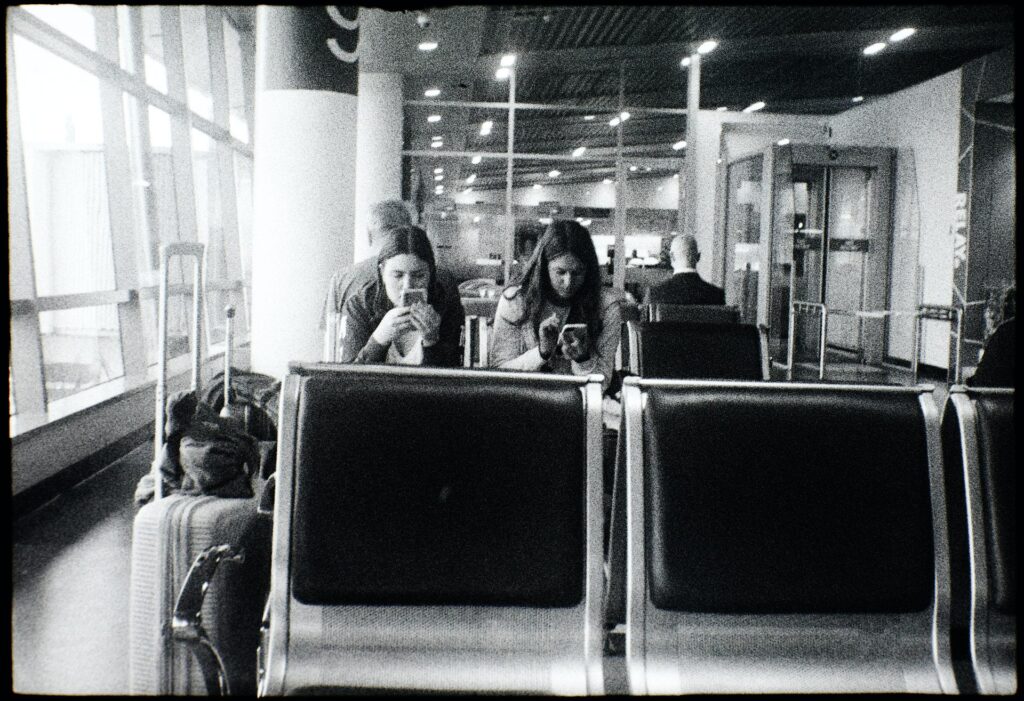 Waiting for their flight at Dunedin airport. Quite weak light on Superpan.