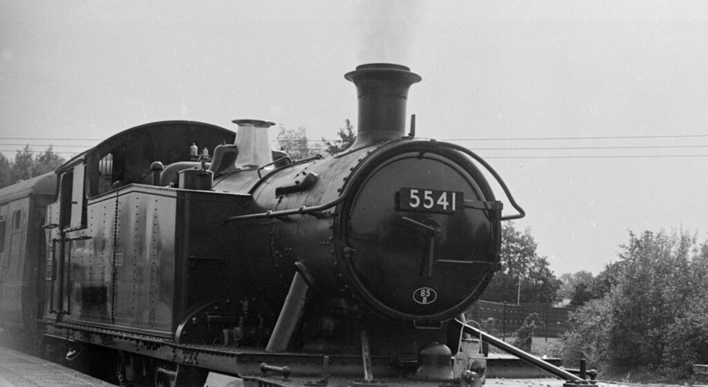 An old steam train engine, with it's number on the front plate.