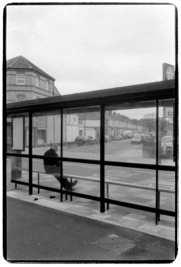A man sat at a bus stop.