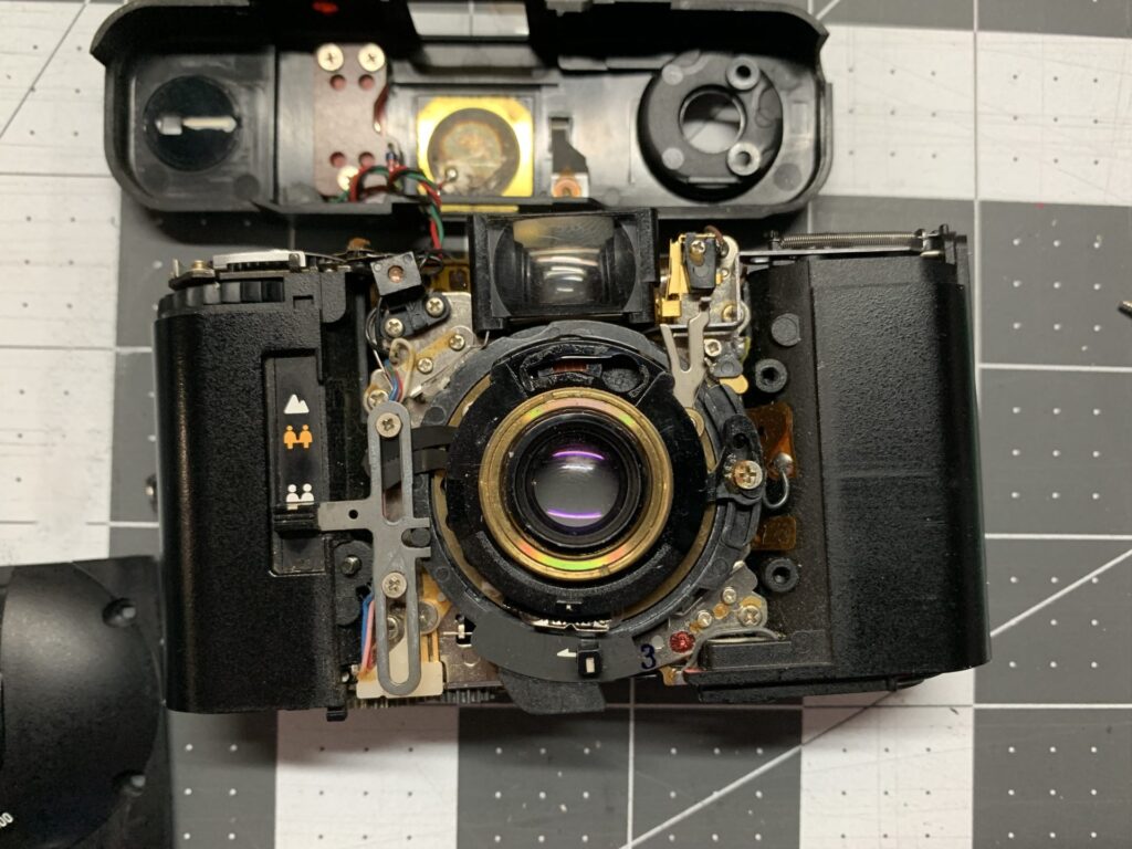 A photo of an xa2 with its case open on a workbench , showing the broken light meter.