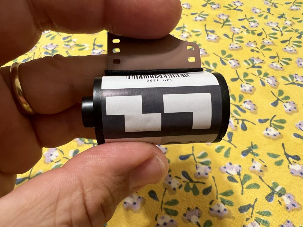 A photo of a film cartridge, held in a hand, showing the fake DX code on the label. 