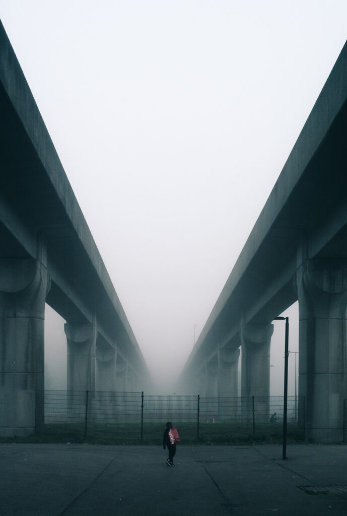 Boy walking under metro tracks