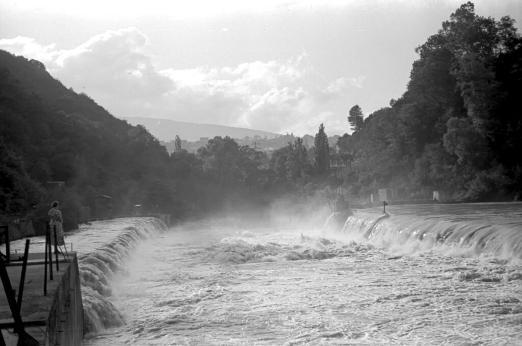 Black and white image of water rushing over a hydro-electric barrage near Annecy, France.