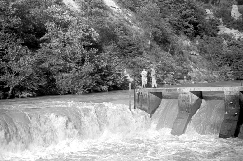 Black and white image of water rushing over a hydro-electric barrage near Annecy, France.