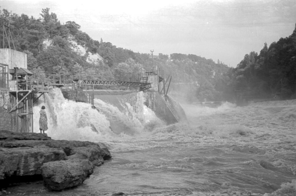 Black and white image of water rushing over a hydro-electric barrage near Annecy, France.