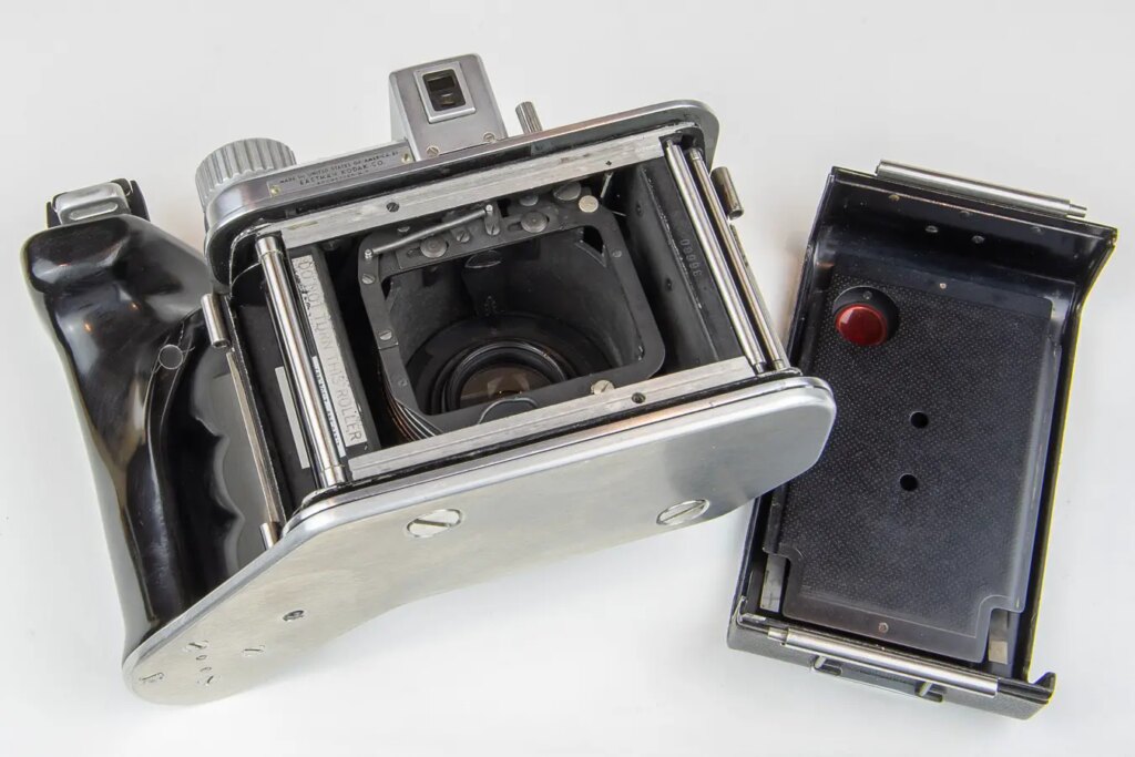 Lens carrier shown in the collapsed position. Grip attaches to both of the baseplate tripod threads.