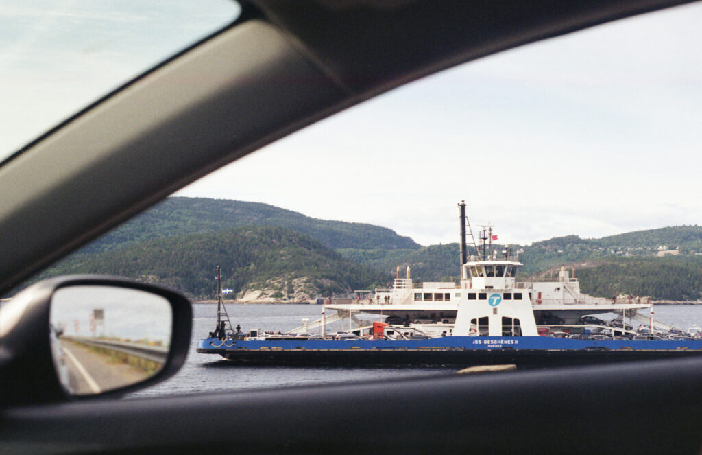 View of the ferry from the passenger window, wing mirror showing the road behind 