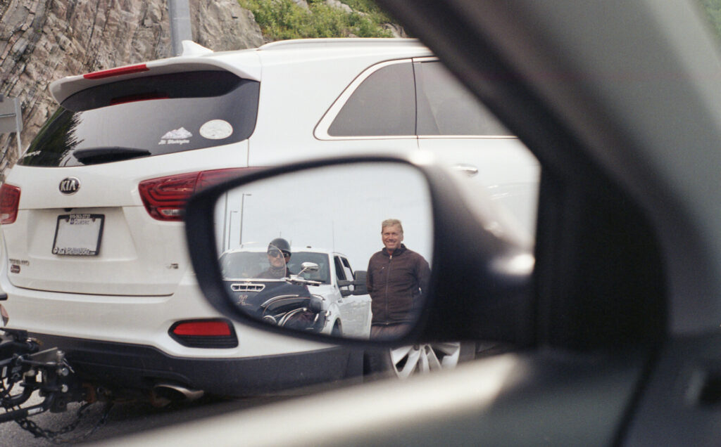 Driver side wing mirror showing motorcyclists behind