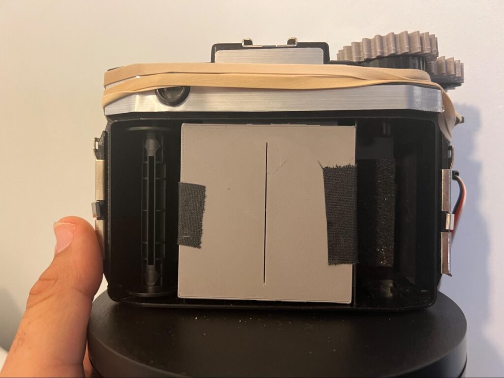 A photo of the open back of a holga showing a 3d printed insert. 