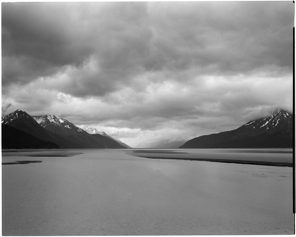 black and white photo of a mountain fjord in alaska
