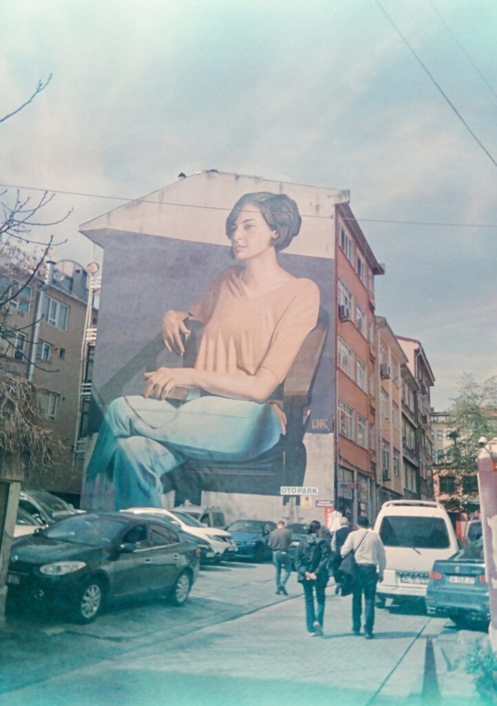 A street mural of a woman lounging on a chair
