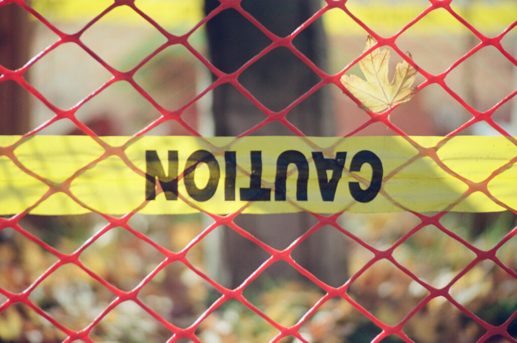 Yellow Caution ribbon upside down and a yellow leaf