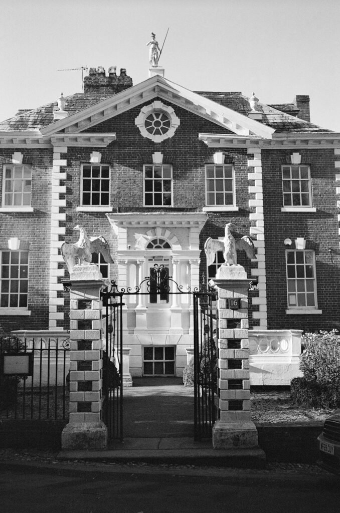Black and white photo of the central portion of the front of a gated Georgian townhouse.