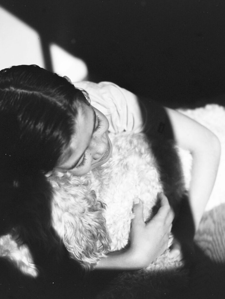 A young boy hugging his dog.