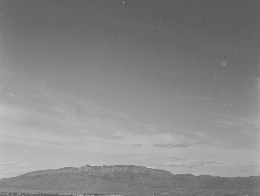 Distant Sandia mountains agains a sky with whisky clouds.