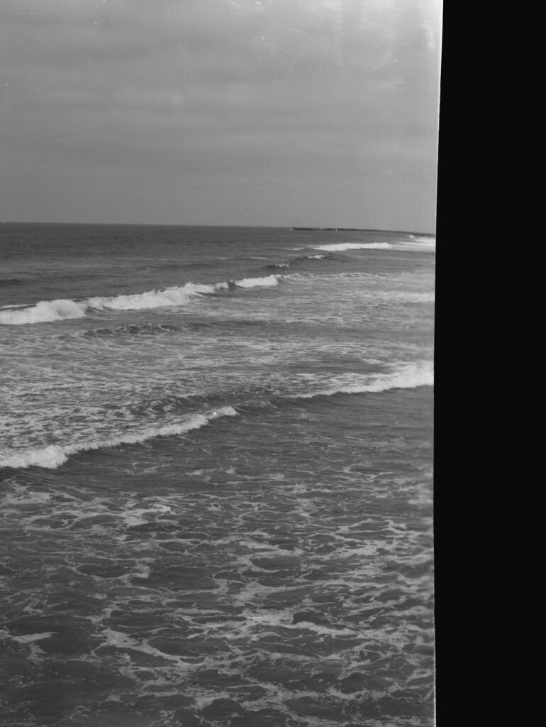 Picture of the ocean with a few rolling waves with a quarter of the image blacked out. 