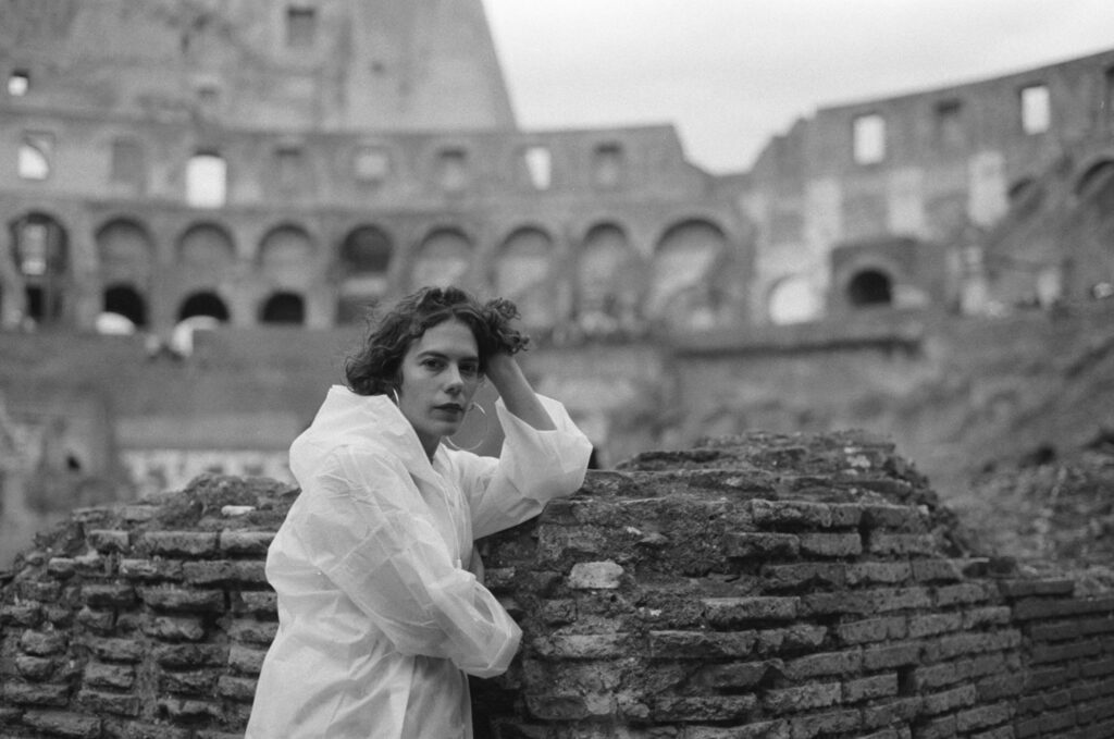 a woman leaning on a wall within the colosseum