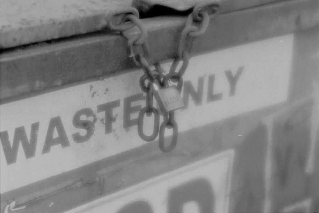 Closeup of the padlock on a dumpster with a soft glow.