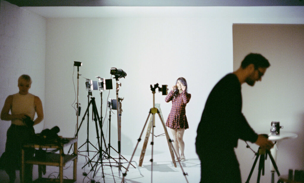 Three people in photography studio preparing for photo shoot