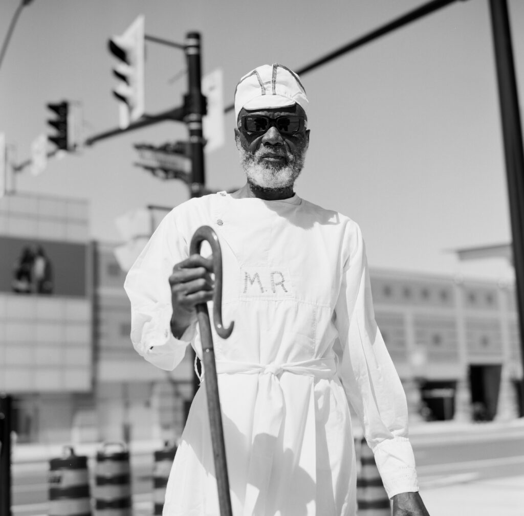 Man in white robe carrying staff