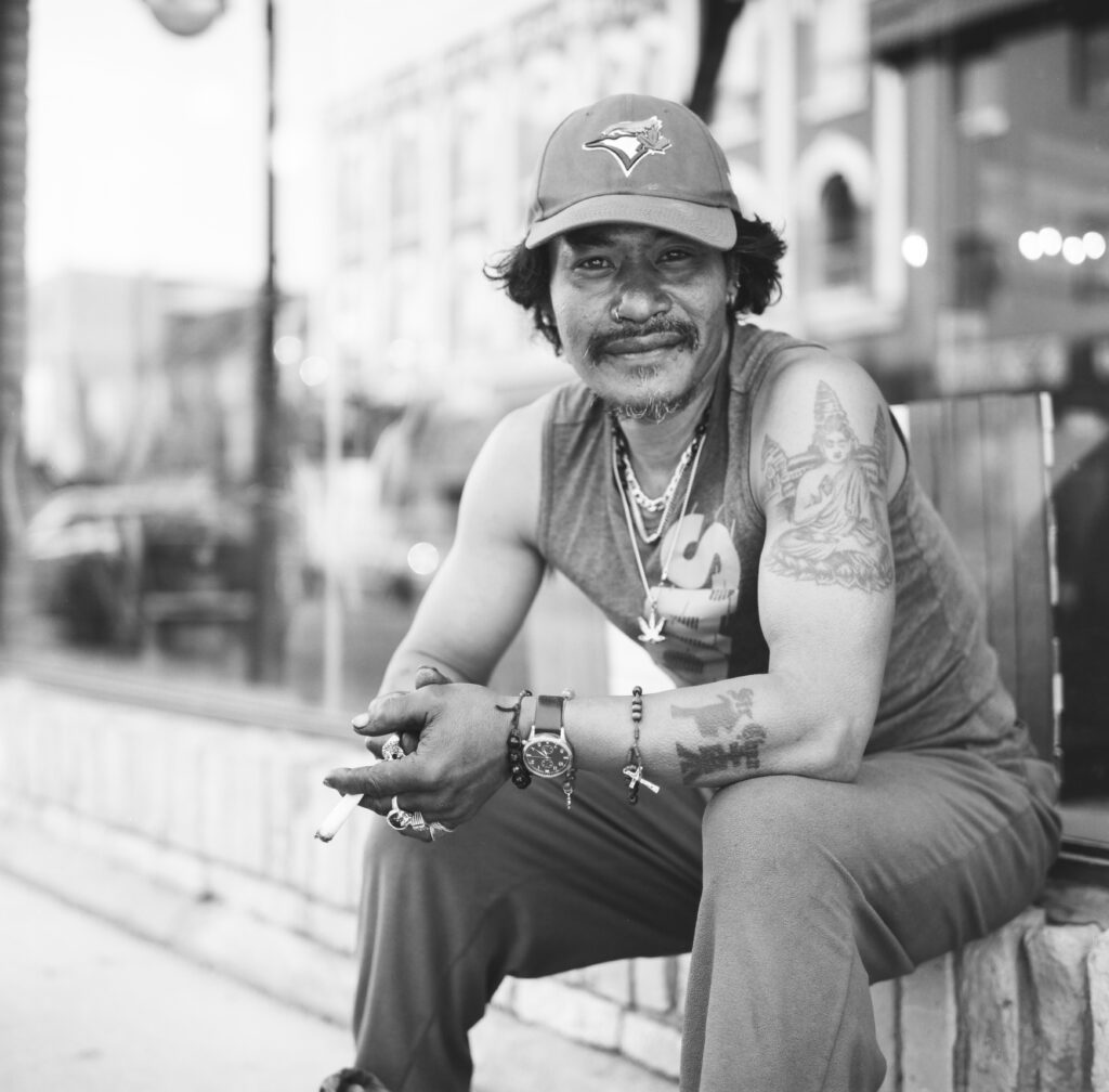 Man sitting on side of street