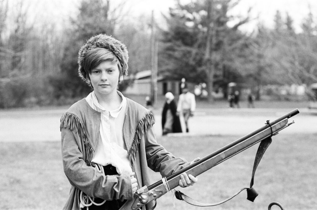 Boy in fur hat holding musket