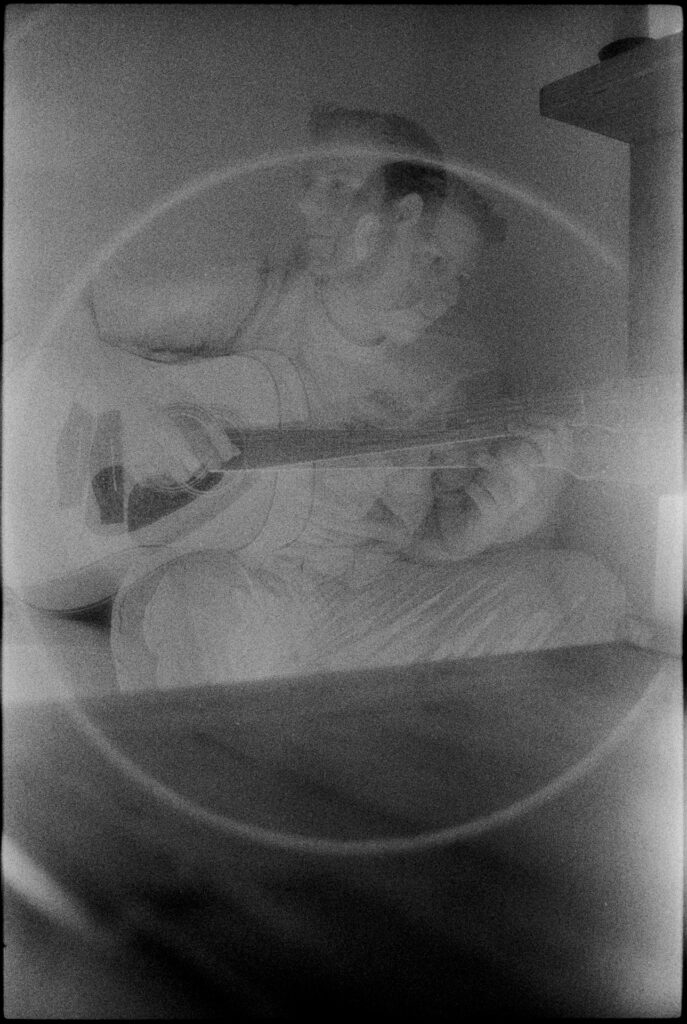 Black and white infrared with a man playing guitar, double exposed.