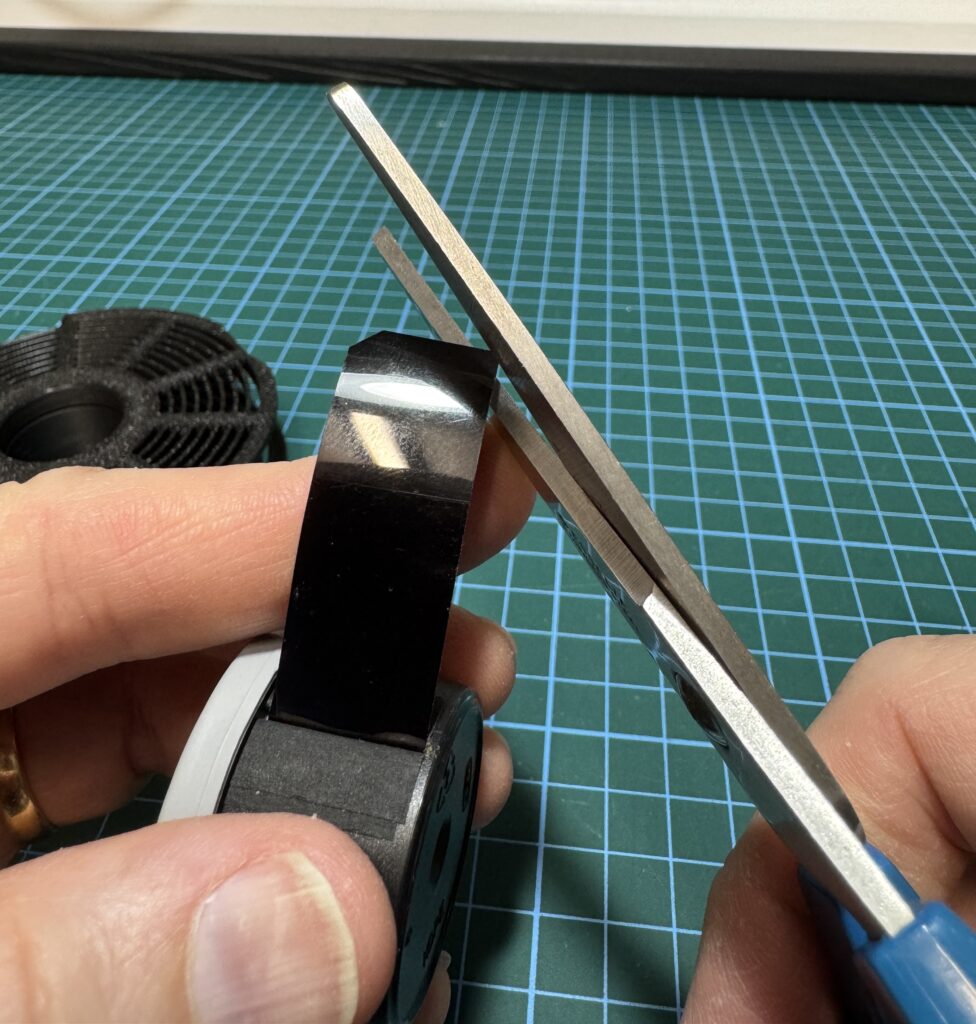 Sharp corners on the end of the film can catch on the grooves and ribs of the reel, so it's best to trim them off, albeit, in the dark