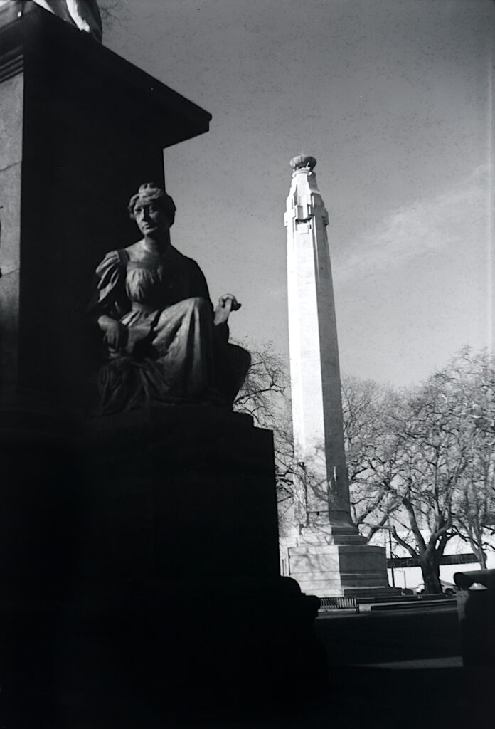 Detail of the Queen Victoria monument in Dunedin’s Queen’s Gardens with Cenotaph beyond.