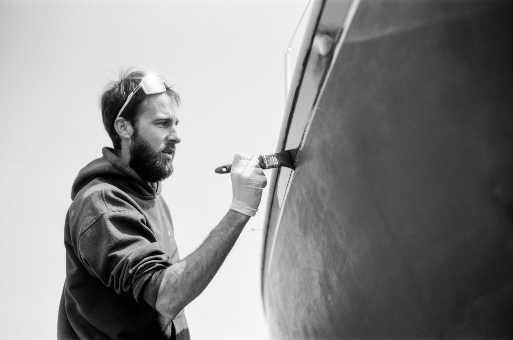 Man painting hull of boat