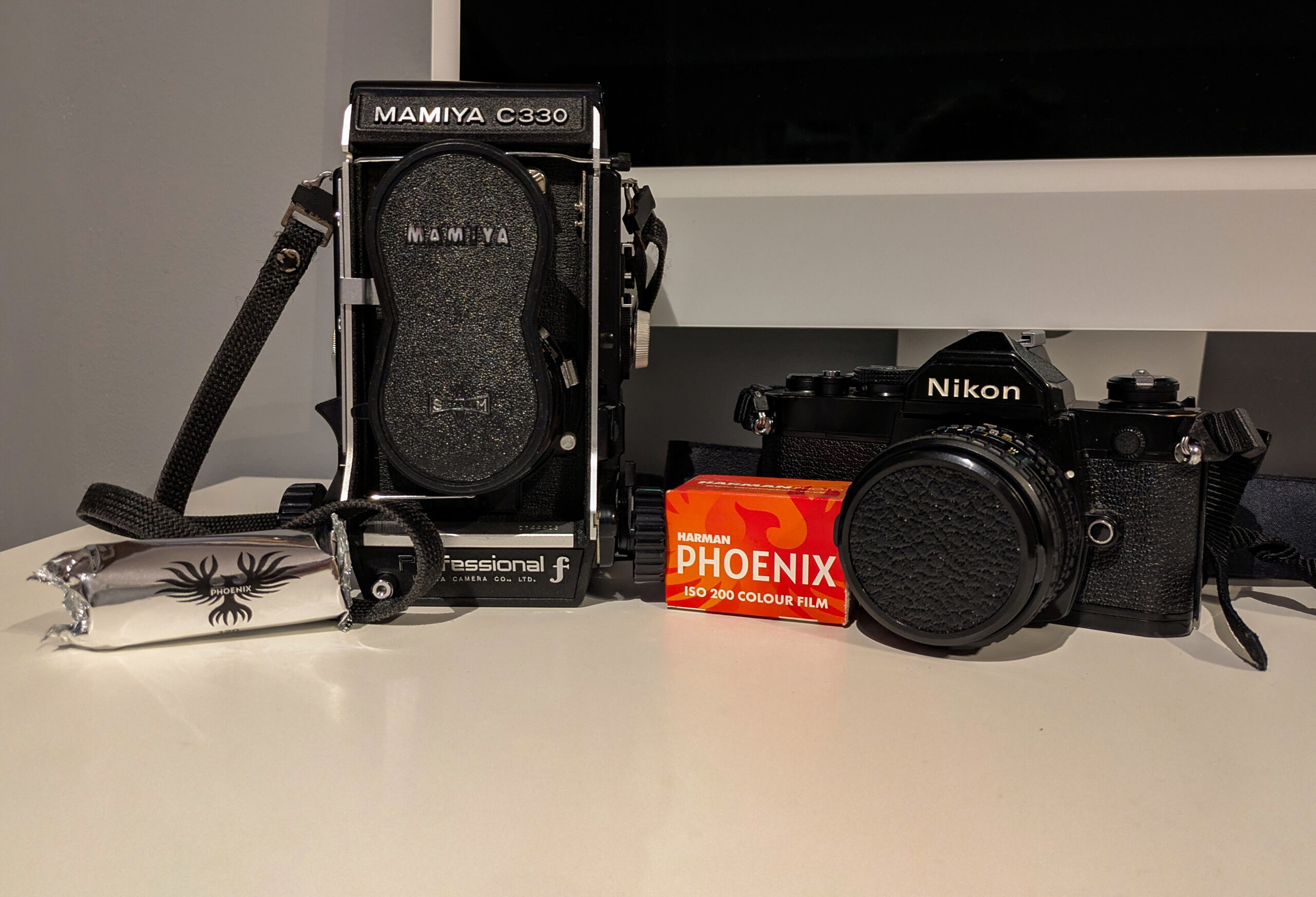 A mamiya C330 F and a Nikon FM with a Phoenix box and a roll of Phoenix 120