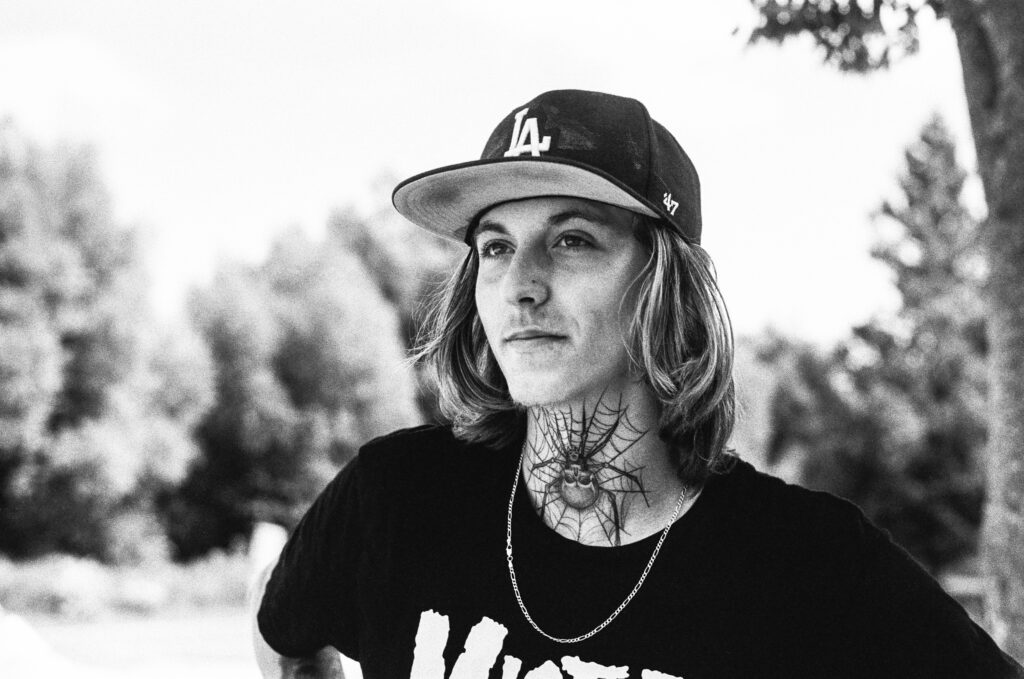 Young man with spider tattoo on neck
