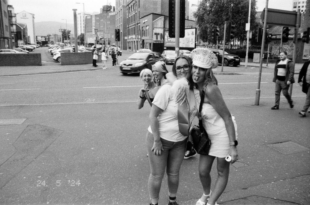 A group of four women pose on the street in Belfast at the beginning of a hen night.
