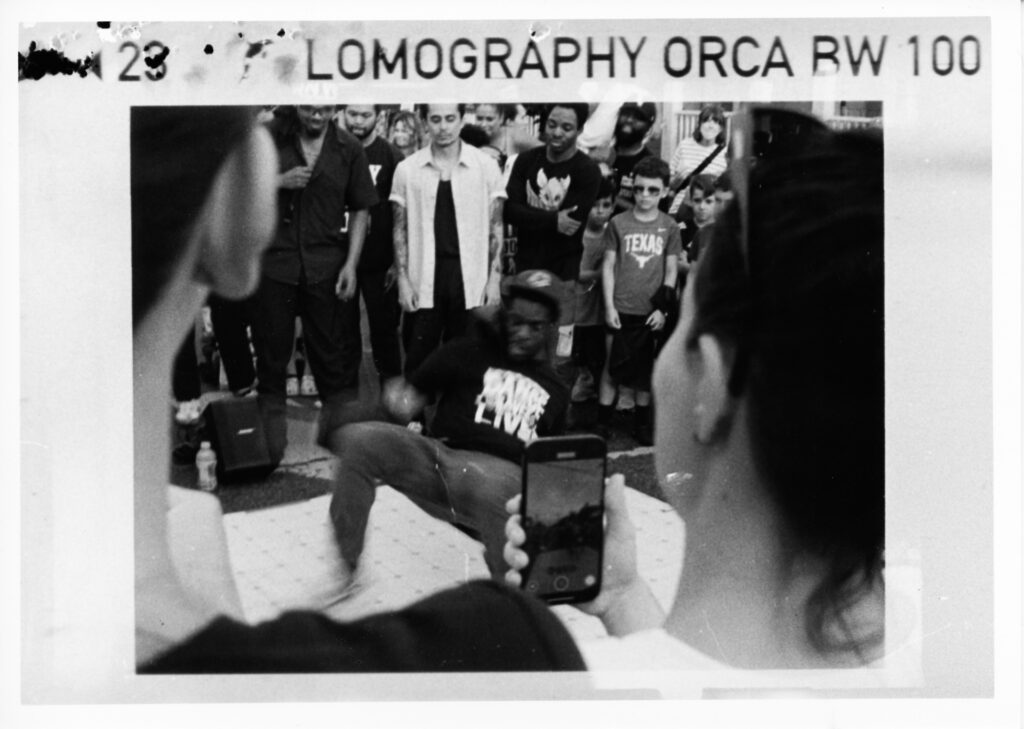 Black and white photo of a break dancer and a crowd of onlookers