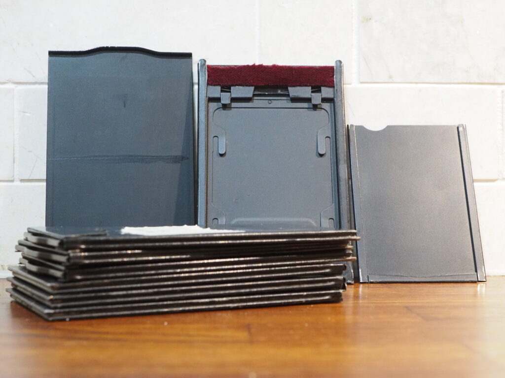 Glass plate holders. The light seals are made from a very long red felt. Also shown is a film sheet insert for one of the holders.