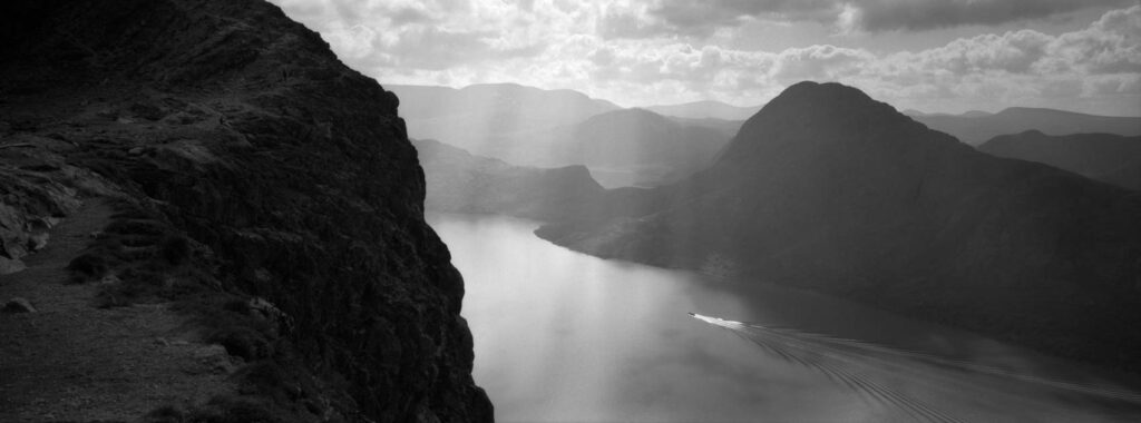 A tiny boat in a fjord in Norway in black and white shot on the Hasselblad XPan 