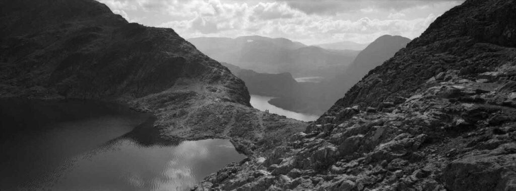 Humans on the Besseggen ridge in Norway with a lake in front and the Fjord in the back shot on the Hasselblad XPan 