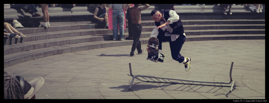 A skateboarder performs a trick jump over a barrier in Washington Square Park's dry fountain.
