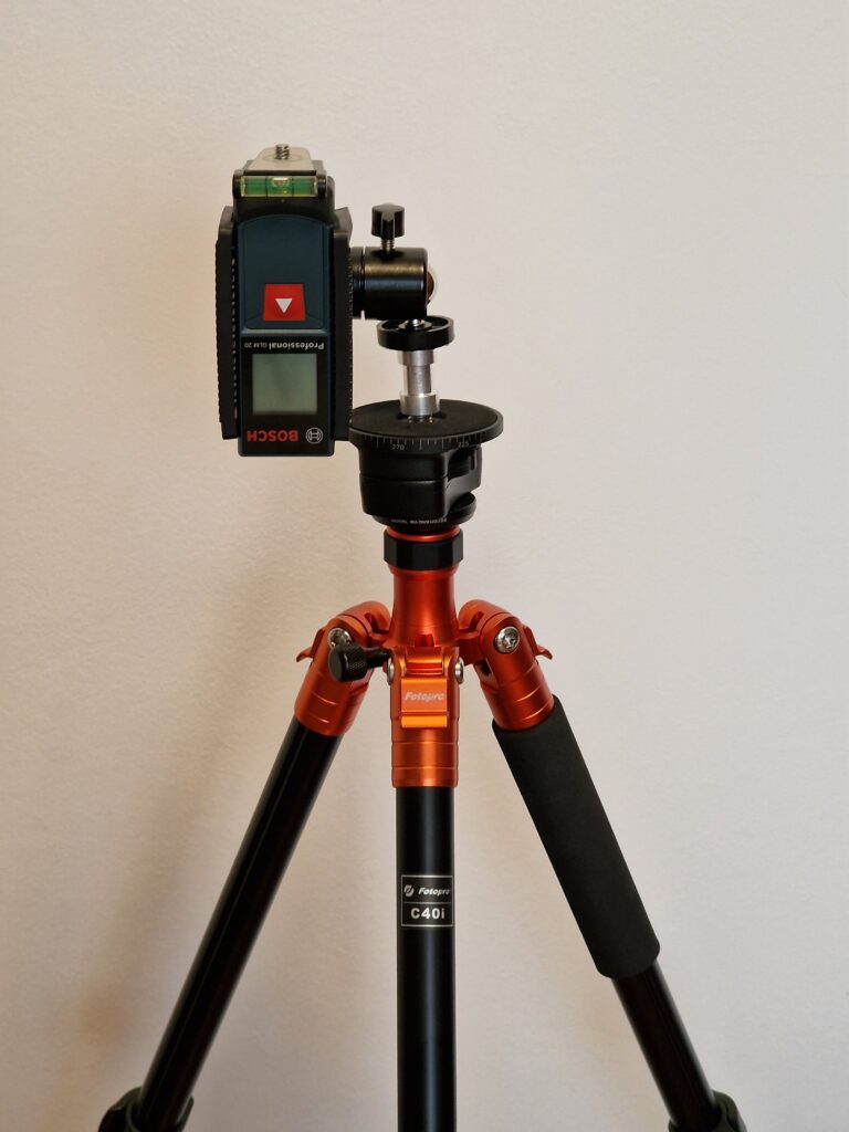 Laser measur device mounted on a tripod via a clamp