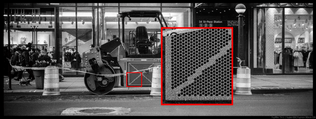 An image of a photo of construction equipment taken from across a street with the 90/4. An inset displays the level of detail available at 100% zoom.