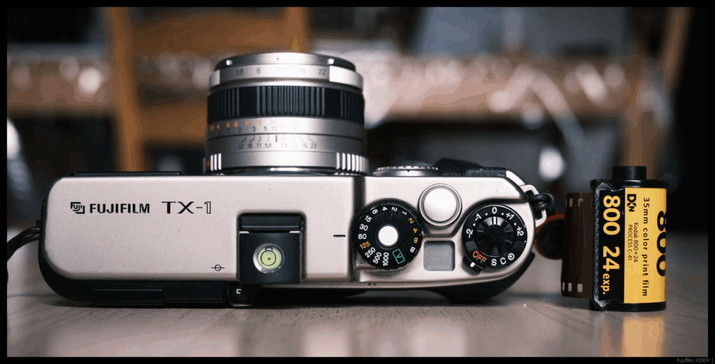 An image of the top of the Fujifilm TX-1 with the 45/4 mounted. A 35mm cassette is placed to the side.