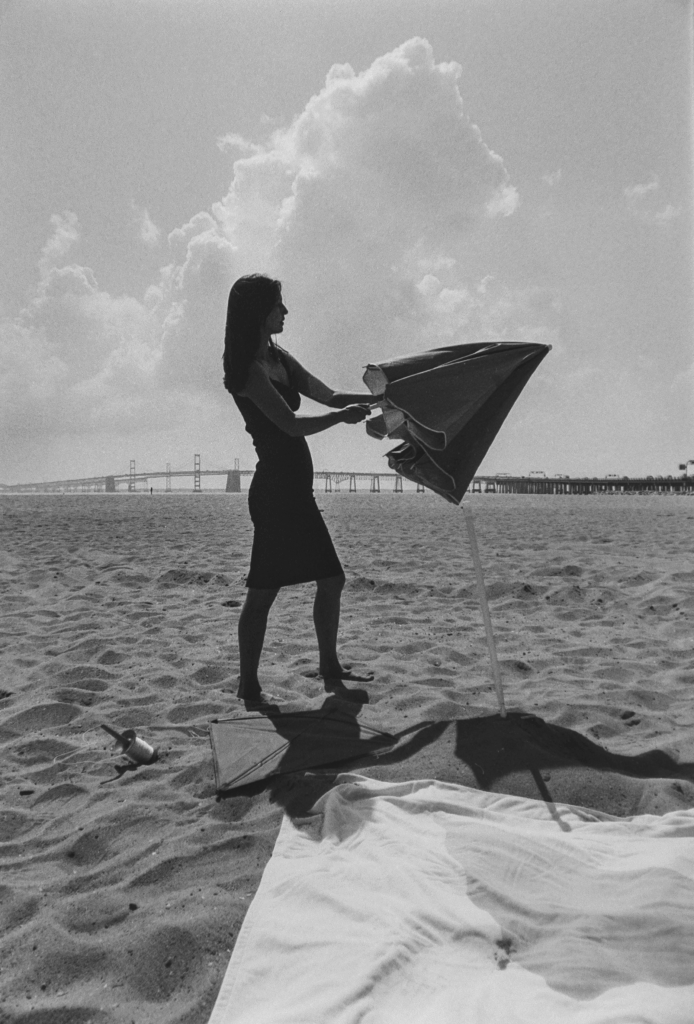 An actor begins to open an umbrella