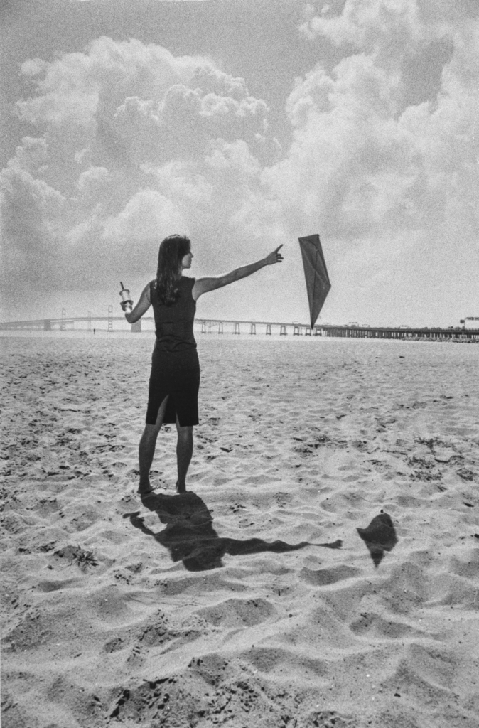 An actor, arm extended, holds a kite.