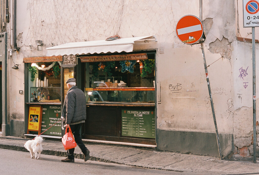A man walking past a small shop